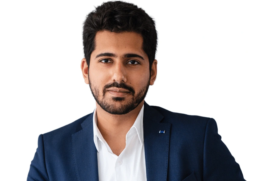 young indian man with black hair in blue blazer against white background